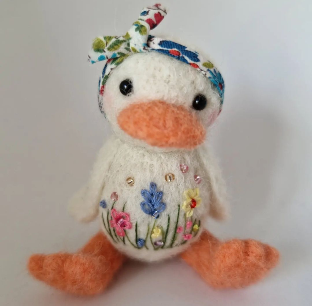 Needlefelt duck with embroidered meadow flowers wearing a floral headscarf