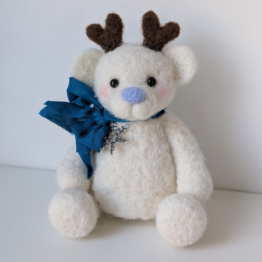 white bear with blue ribbon and nose with reindeer antlers