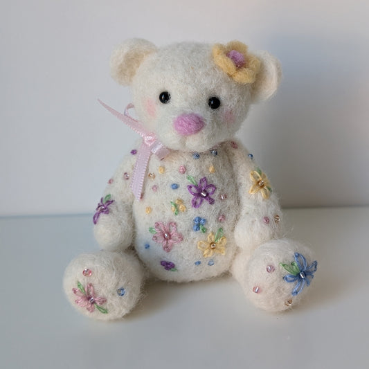 White teddy bear with floral patterns on a white background