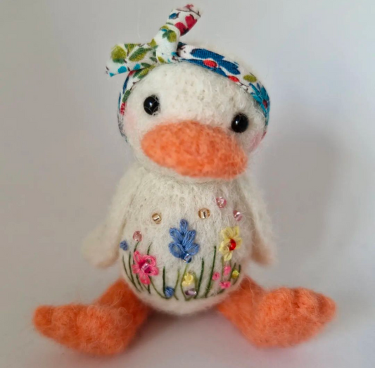 Needlefelt duck with embroidered meadow flowers wearing a floral headscarf